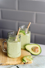 creamy smoothie from avocado and banana in glass cups with paper tubes on a light background. no plastic. healthy food