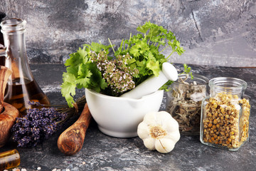 .Fresh herbs in mortar bowl from the garden and the different oils for massage and aromatherapy.