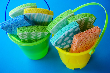 Plastic buckets full of colorful sponges for keeping home ultra clean in fight against coronavirus. © VinceZen