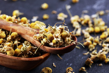 Heap of dried chamomile lying on rustic surface. healthy nutrition concept, herbalism and alternative medicine with chamomile