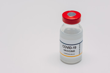 conceptual vial of covid-19 or coronavirus vaccine against a white background