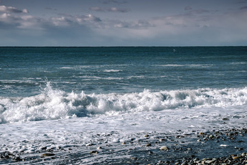 Waves in the sea roll ashore splashing sea water. Landscape beautiful sea view