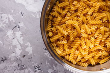 Traditional Italian pasta in a metal pan on a stone background