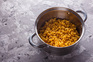 Traditional Italian pasta in a metal pan on a stone background