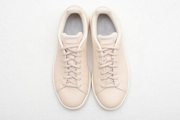 New beige women's sneakers, white background, top view, copy space
