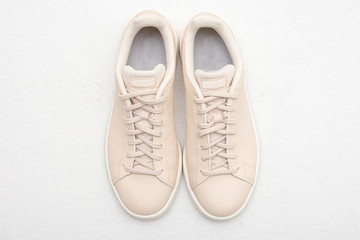 New beige women's sneakers, white background, top view, copy space