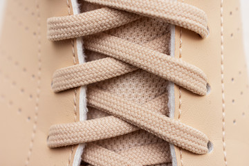 Lace on beige sneakers, close up