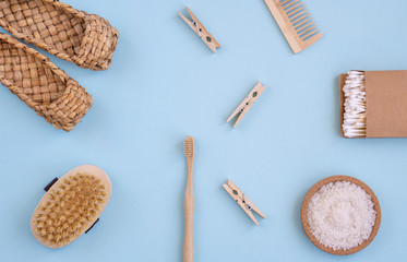 Zero Waste Set For Bathing On Light Blue Background. Natural sisal brush, wooden comb, sea salt, bamboo toothbrush, washcloth and cotton buds.    Top view, flat lay,