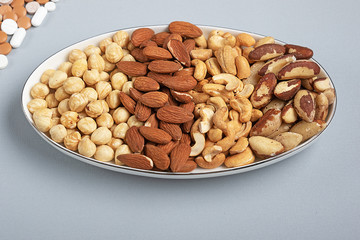 Four kinds of roasted nuts on plate. Healthy fats for health