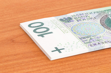 Close-up of part of stack of 100 PLN banknotes.