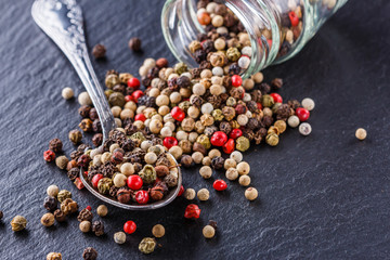 mix of peppercorns on a dark stone background