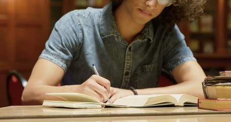 Man studying in the library - Powered by Adobe