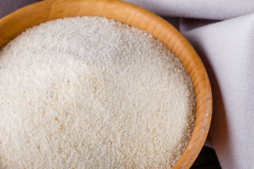 natural organic semolina on dark wooden rustic background