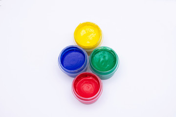 Cans of different colors gouache paints, top view, closeup, white background, copy space