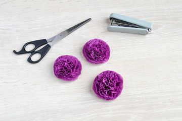 Naklejka premium A finished peony bud from a purple paper napkin. Do-it-yourself little paper flowers step by step.