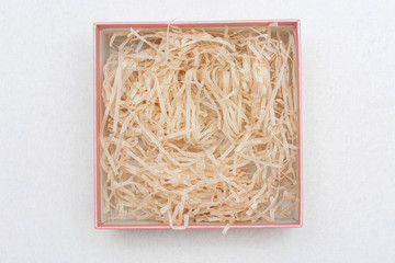 Opened box with decorative straw or shavings, top view, copy space
