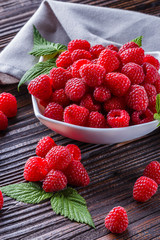 juicy fresh natural raspberries on a dark wooden rustic background