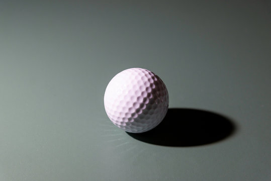 A low key image of a golf ball.