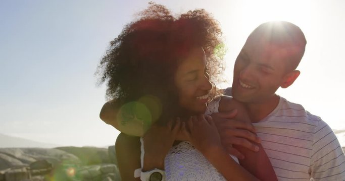 Couple embracing each other on beach in the sunshine