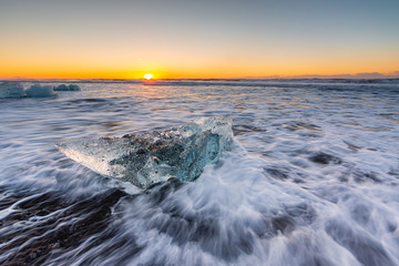 Golden ice on the black beach near Jokulsarlon glacier lagoon, daimond beach, South Iceland.