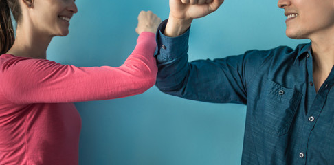 Elbow bump greeting to avoid the spread of coronavirus. Two people friends greet by bumping elbows instead of greeting with a hug or handshake. Don't shake hands. 