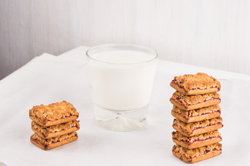 Freshly baked homemade cookies with jam in stack with milk in glass. Balanced nutrition, proteins and carbohydrates, cereals