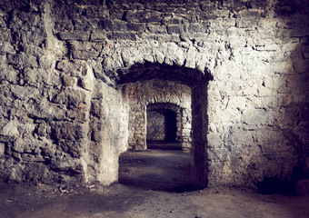Basement tunnel of the old castle. The stone walls of the prison. A long corridor through several rooms. Earthen floor.