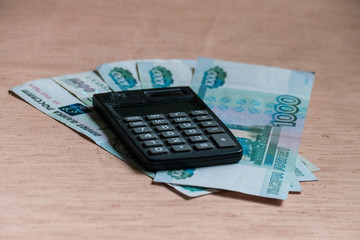 Russian rubles and calculator on a brown table