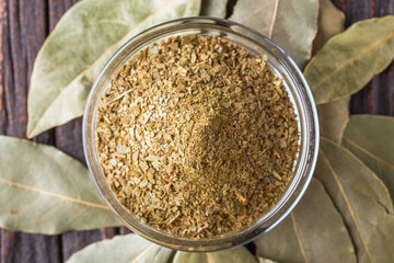 ground dried bay leaf on dark wooden rustic background