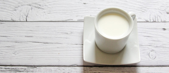 Fototapeta na wymiar Cup of warm milk on a wooden background. White Cup with milk.