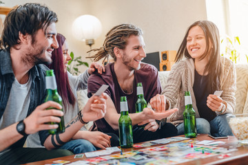 Company of young people playing in board games at home