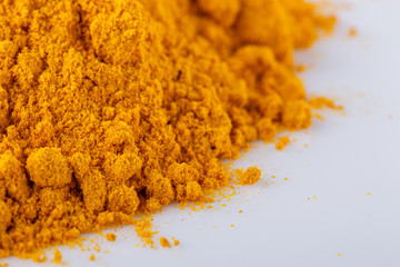 natural turmeric powder on white acrylic background