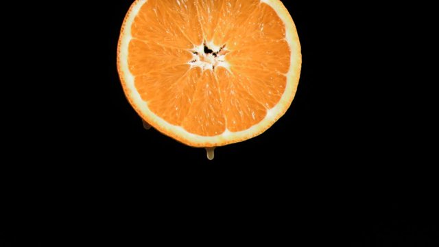 Drop falling in super slow motion from an orange slice