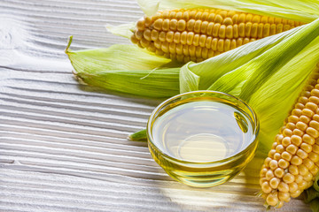 corn oil on white wooden rustic background