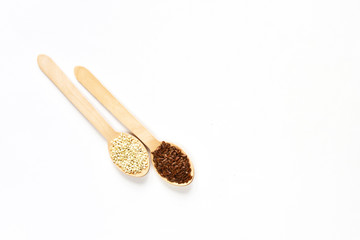 Flax seeds in a wooden spoon on a white background. View from above.