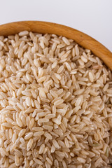 raw brown rice on white acrylic background