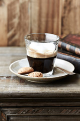 Cup of coffee with amaretti (Italian biscuits) on rustic wooden background. 