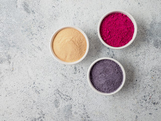 Set of superfoods in white bowls on grey background.