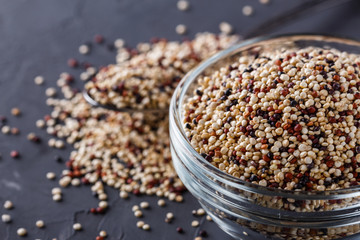 mix of quinoa grains on a dark stone background