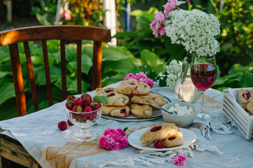 Sweet buns on a table with strawberries. Rustic style photo in nature.