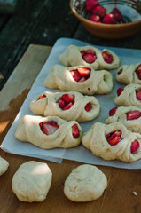 Women bake strawberry Buns. Dough on the table. Knead the dough.