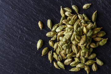 fragrant green cardamom on a dark stone background