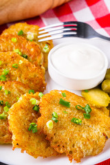 Delicious crispy potato pancakes on dark stone background