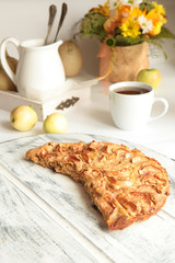 Freshly baked apple pie with apples in the background.