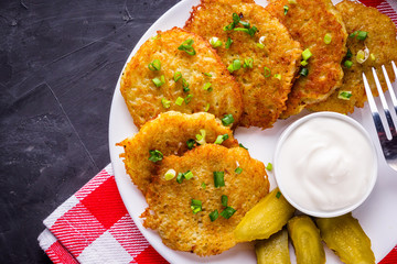 Delicious crispy potato pancakes on dark stone background