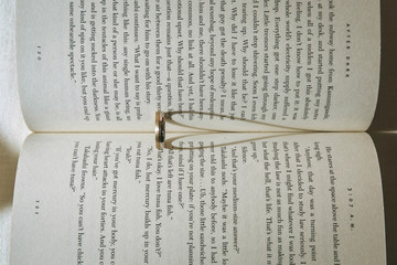 Wedding rings on book and hearts