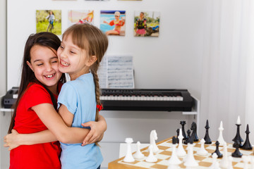 Two cute children playing chess at home