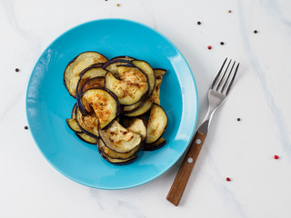 Top view of fried aubergine in the blue plate.