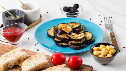 Fried aubergine in the blue plate.
