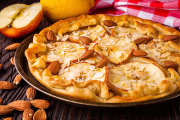 crispy apple galette with almonds on rustic wooden background